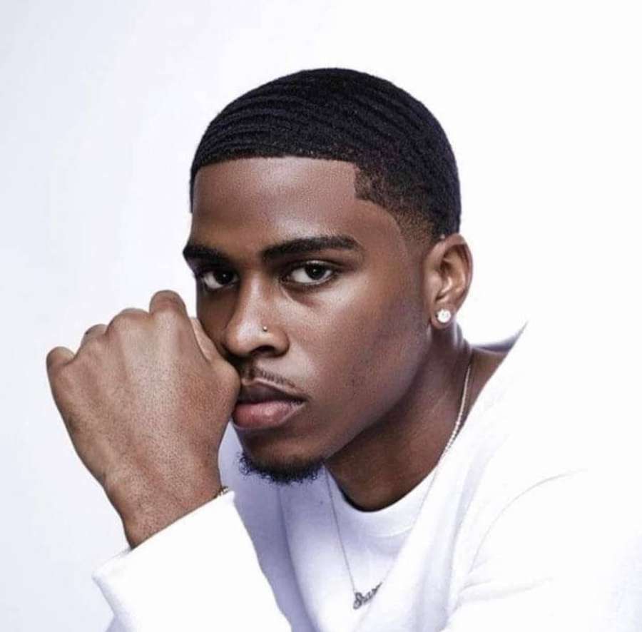 Young man with braids and jewelry posing in studio — Swavy Background