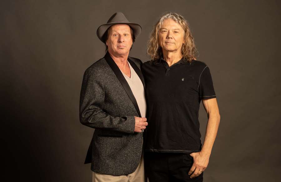 Two men in casual attire posing for a studio portrait against a gray background. — Talking heads Wallpaper