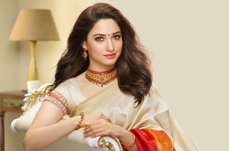 Woman in cream sari with red gold jewelry posing beside a lamp. — Tamanna HD Wallpaper