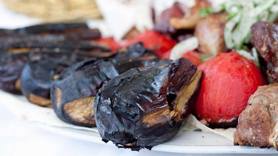 Berinjela grelhada e tomates com carne em um prato branco. — Tâmaras Papéis de Parede