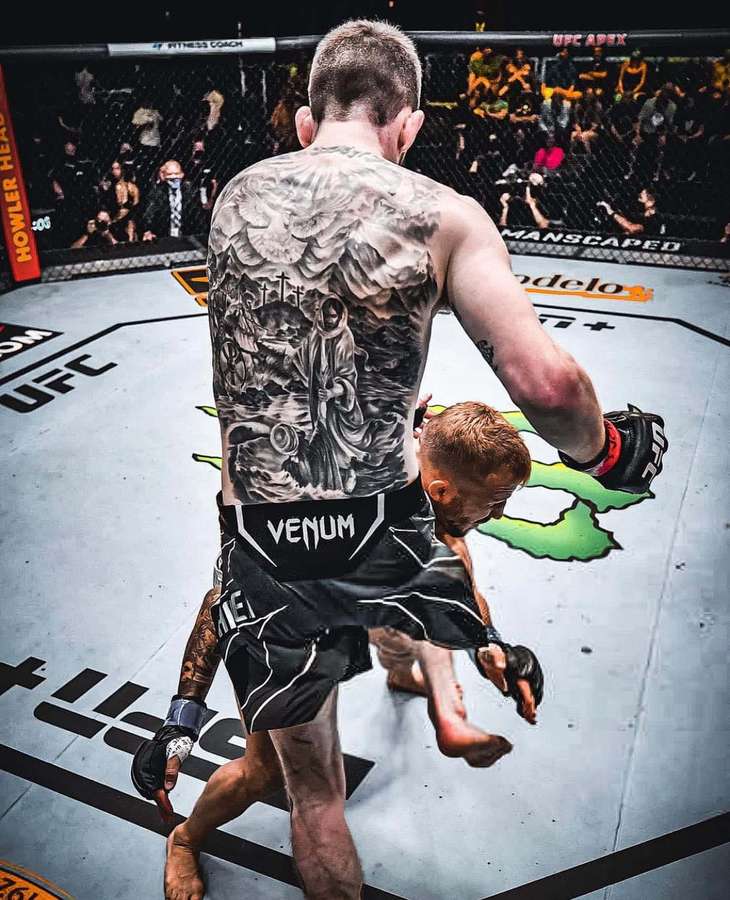 MMA-Kämpfer mit Rücken-Tattoo hebt Gegner im UFC-Oktagon. — Tattoo Bilder