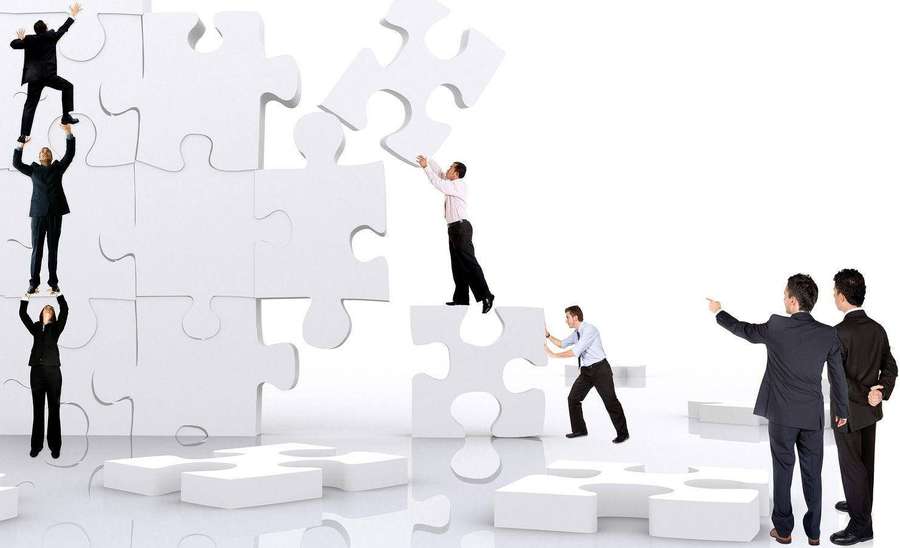 Team di affari che assembla grandi pezzi di puzzle bianco per formare una struttura. — Teamwork Sfondi