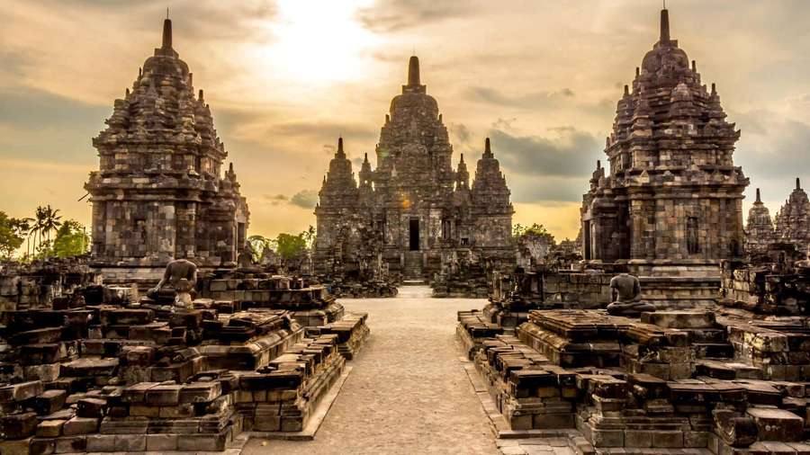 Sunset over ancient stone temple complex with tiered spires and stone pathways. — Temple Picture