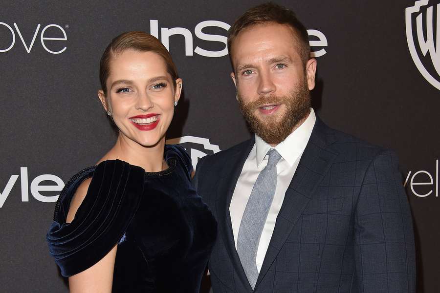 A man and woman in formal attire smiling at a branded event. — Teresa Wallpaper