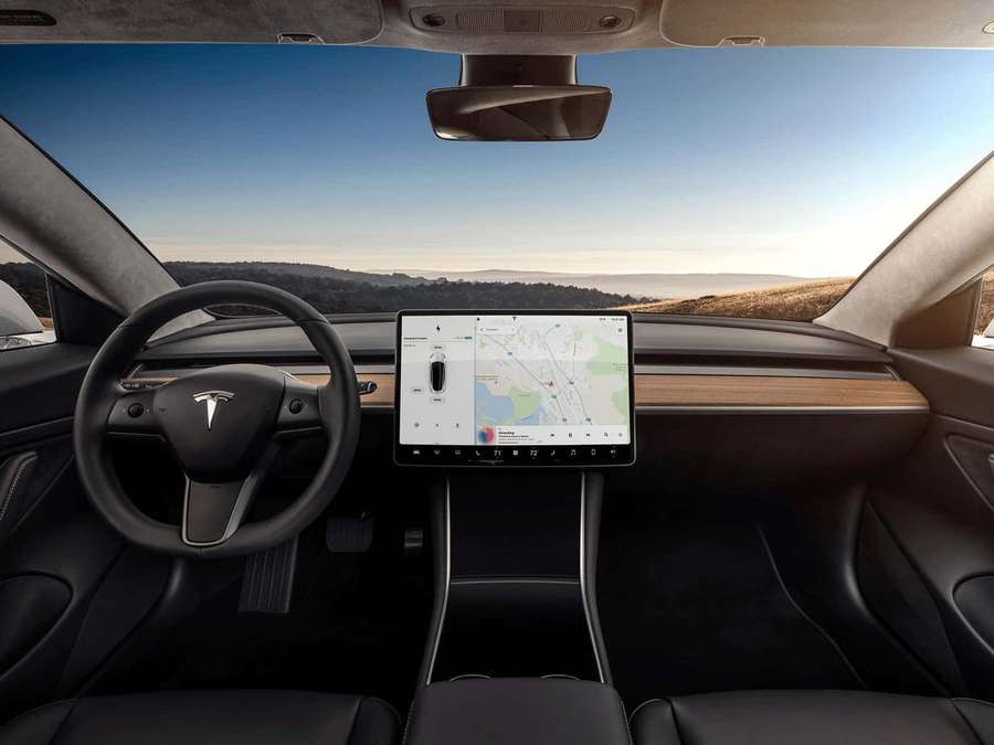 Tesla car interior showing navigation screen and desert view at sunset. — Tesla Model 3 Wallpaper