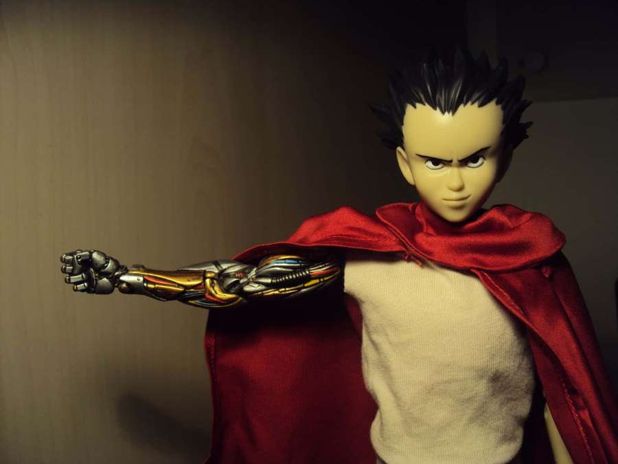 Anime action figure with red cape and mechanical arm posing heroically. — Tetsuo Shima Wallpaper