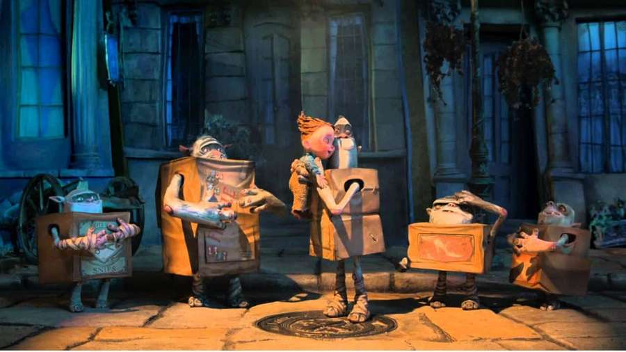Viisi pahvilaatikko-olentoa, joilla on kasvot ja raajat, seisovat mukulakivikadulla yöllä. — The boxtrolls Taustakuvat