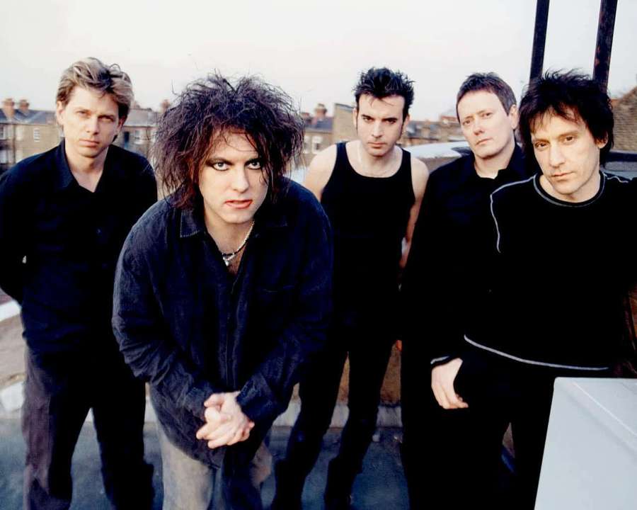 Five men in black clothing pose seriously on a city rooftop. — The cure Wallpaper