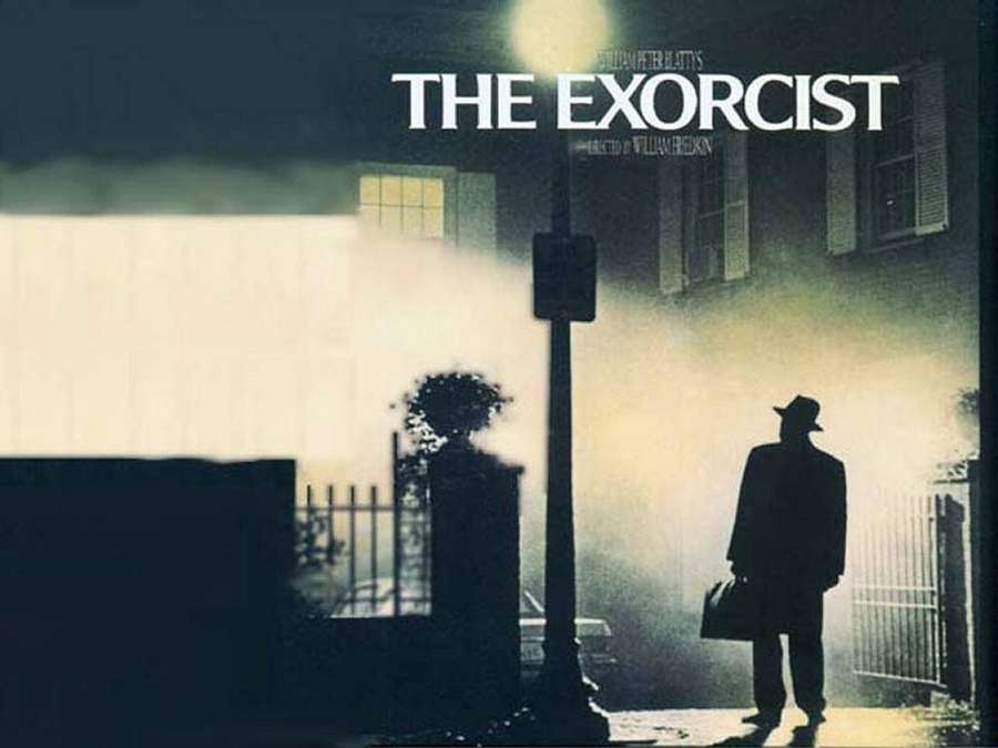 Silhouetted man in fedora and trench coat standing in foggy urban street at night. — The Exorcist Wallpaper