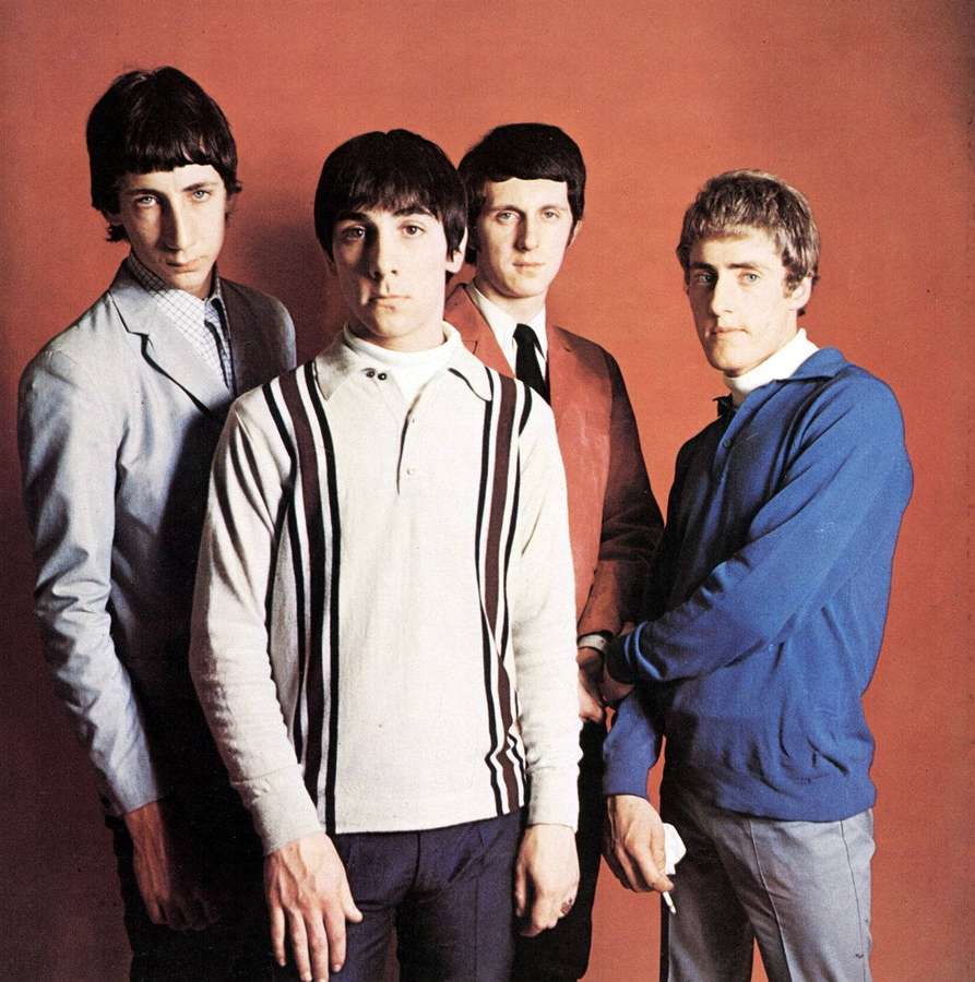 Four men in 1960s clothing pose seriously against a red background. — The who Wallpaper