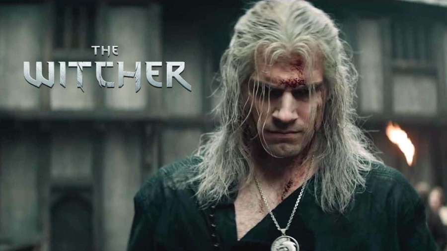 A bloodied warrior with long white hair stares intensely in a dark medieval setting. — The Witcher Netflix Wallpaper