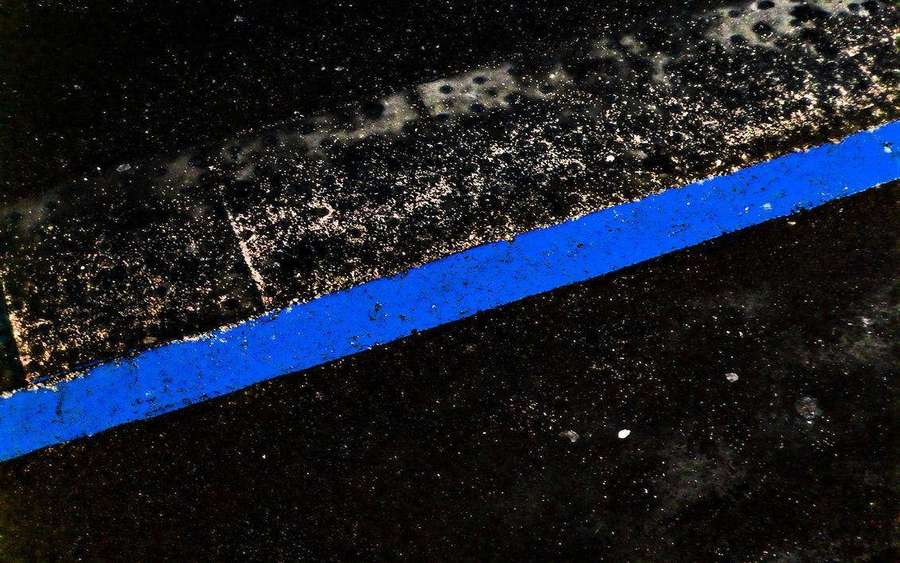 A bold blue line painted on wet asphalt at night. — Thin Blue Line Wallpaper
