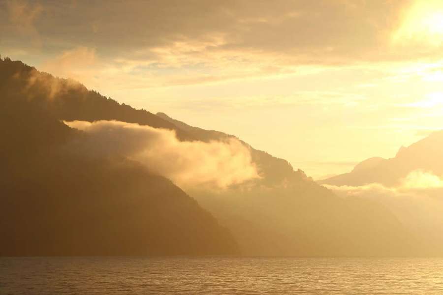 Sunrise over misty mountains and calm water — Thun Wallpaper