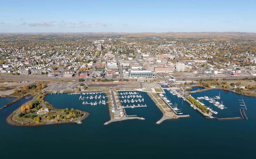 Coastal town with marinas and autumn trees under blue sky. — Thunder Bay Wallpaper