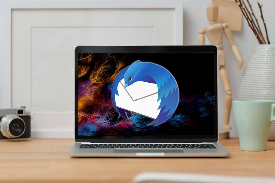 Laptop mostrando pájaro con sobre en fondo abstracto colorido sobre escritorio de madera con cámara y taza. — Thunderbird Fondos de pantalla