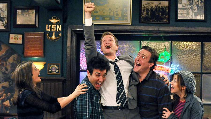 Vier Freunde lachen und jubeln in einer Bar mit Neonlichtern. — Tiffany Bilder