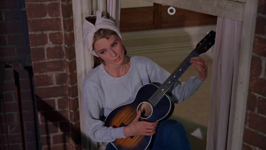 Frau mit Handtuch auf dem Kopf hält Gitarre in Backsteintüröffnung — Tiffany's Wallpaper