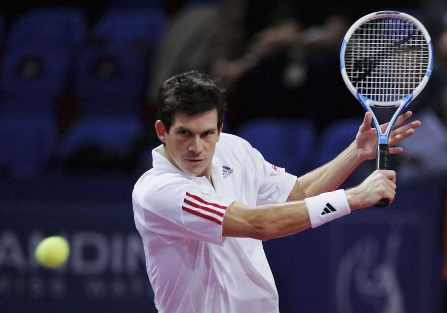 Tennis player swinging racket at ball during indoor match. — Tim Henman Wallpaper