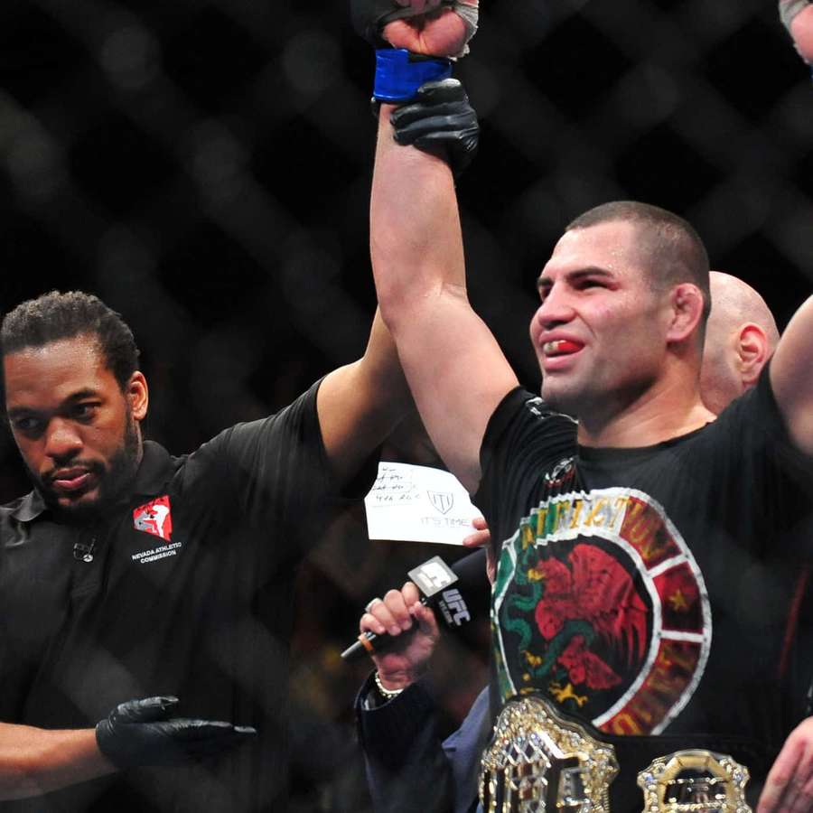 MMA fighter wins championship in cage with referee raising his arm. — Tim Sylvia Wallpaper