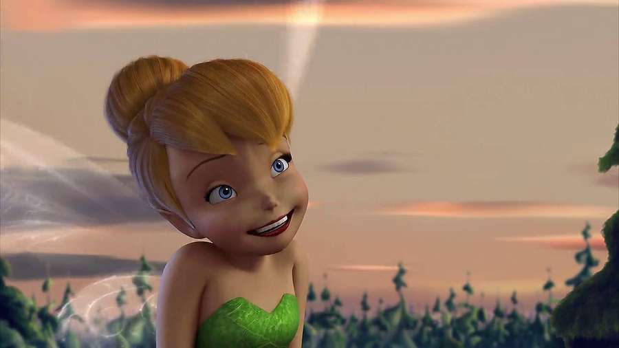 Tinker Bell in grünem Kleid lächelnd bei Sonnenuntergang mit leuchtenden Flügeln. — Tinker Bell Bilder