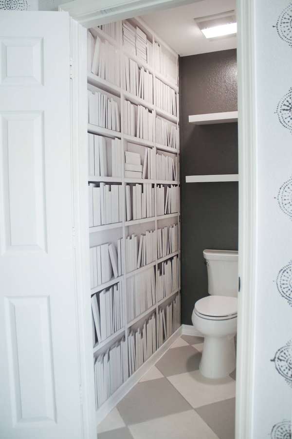 Badezimmer mit Bücherregal-Tapete und Schachbrettboden. — Toilette Wallpaper