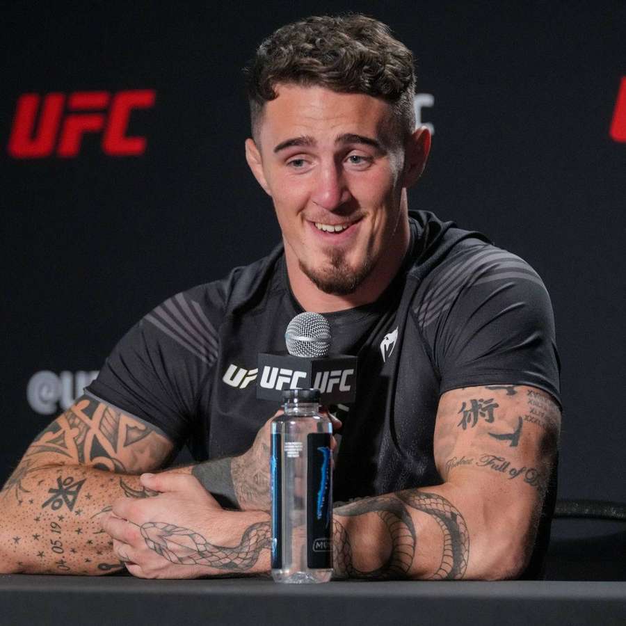 UFC fighter with tattoos smiling at press conference — Tom Aspinall Wallpaper