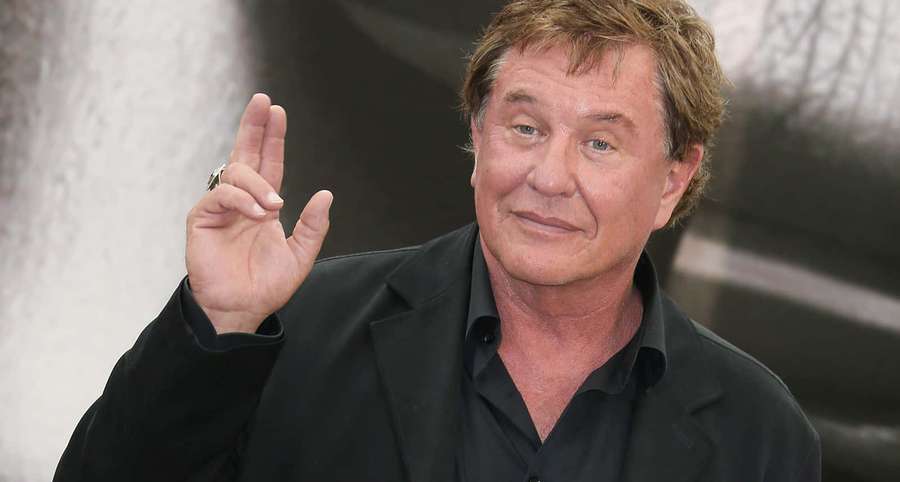 Skuespiller Val Kilmer vinker med et fredstegn i svart dress. — Tom Berenger Bakgrunner