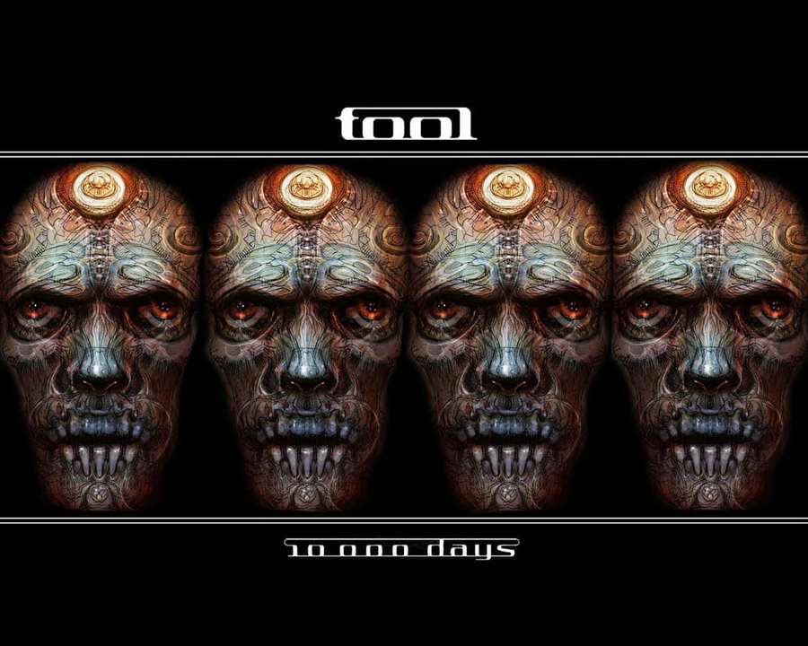 Four identical ornate skulls with glowing eyes and crowns on a black background. — Tool Band Wallpaper