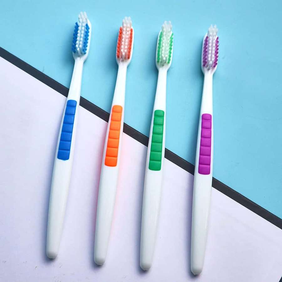 Four colorful toothbrushes with textured grips arranged diagonally on a blue and white background. — Toothbrush Wallpaper