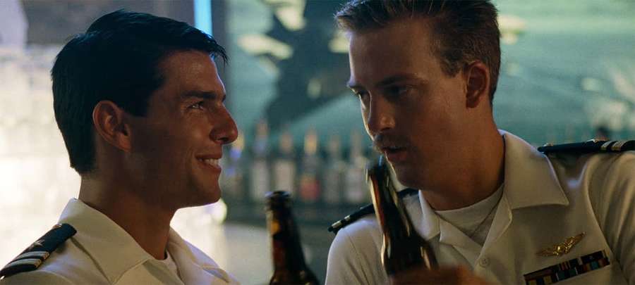 Zwei Männer in Marineuniformen lächeln, während sie in einer Bar Bier halten. — Top Gun Bilder