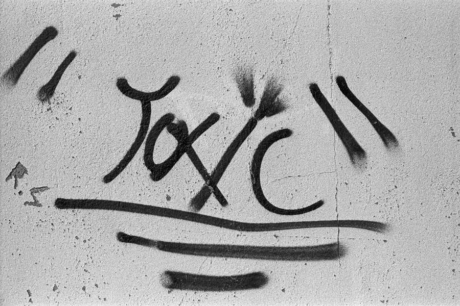 Graffiti word toxic painted in black on a concrete wall. — Toxic Wallpaper