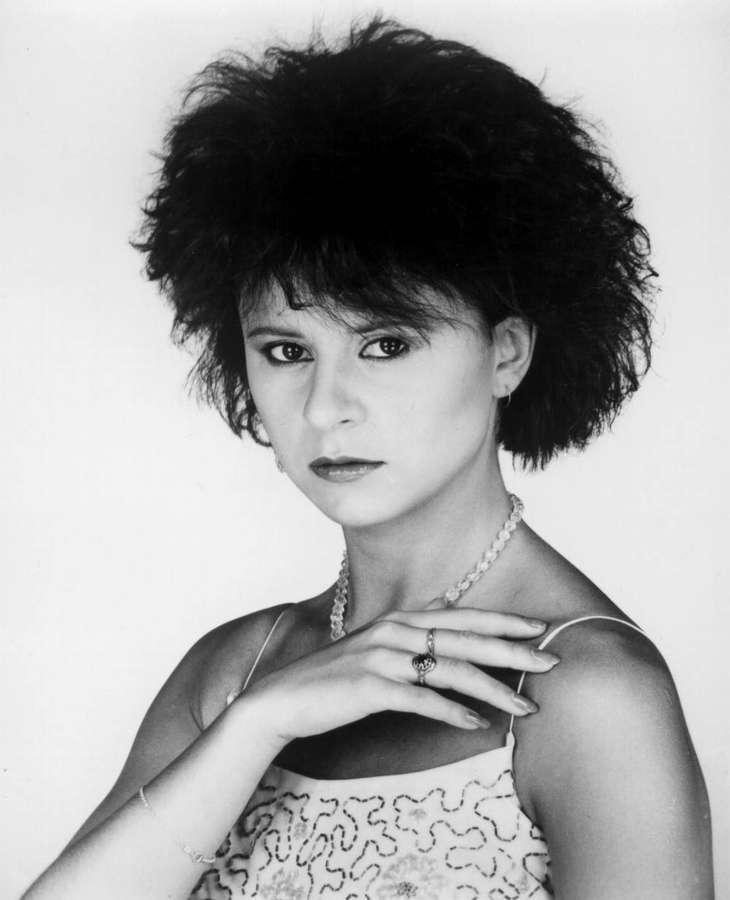 Frau mit 80er-Jahre-Frisur, Perlenkette und gemustertem Top im Studio-Porträt. — Tracey Ullman Bilder