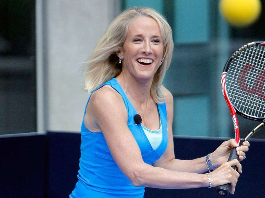 En smilende kvinde spiller tennis med et blåt outfit og rød ketcher. — Tracy Austin Wallpapers
