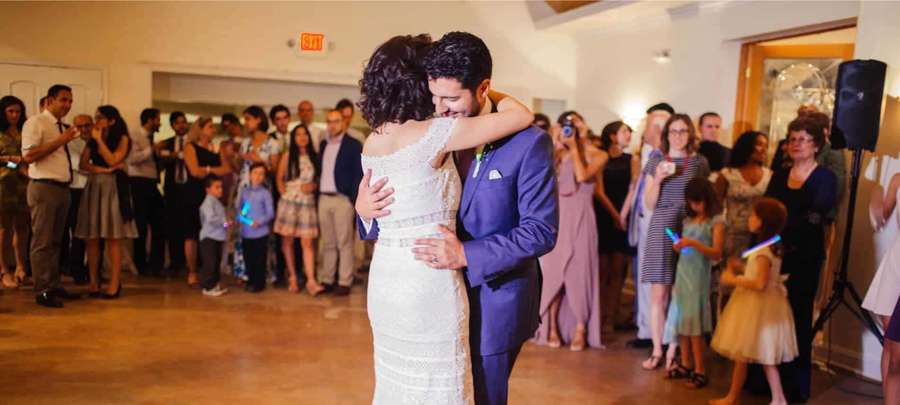 Novia y novio bailando en la recepción de bodas con invitados mirando. — Traje morado Fondos de pantalla