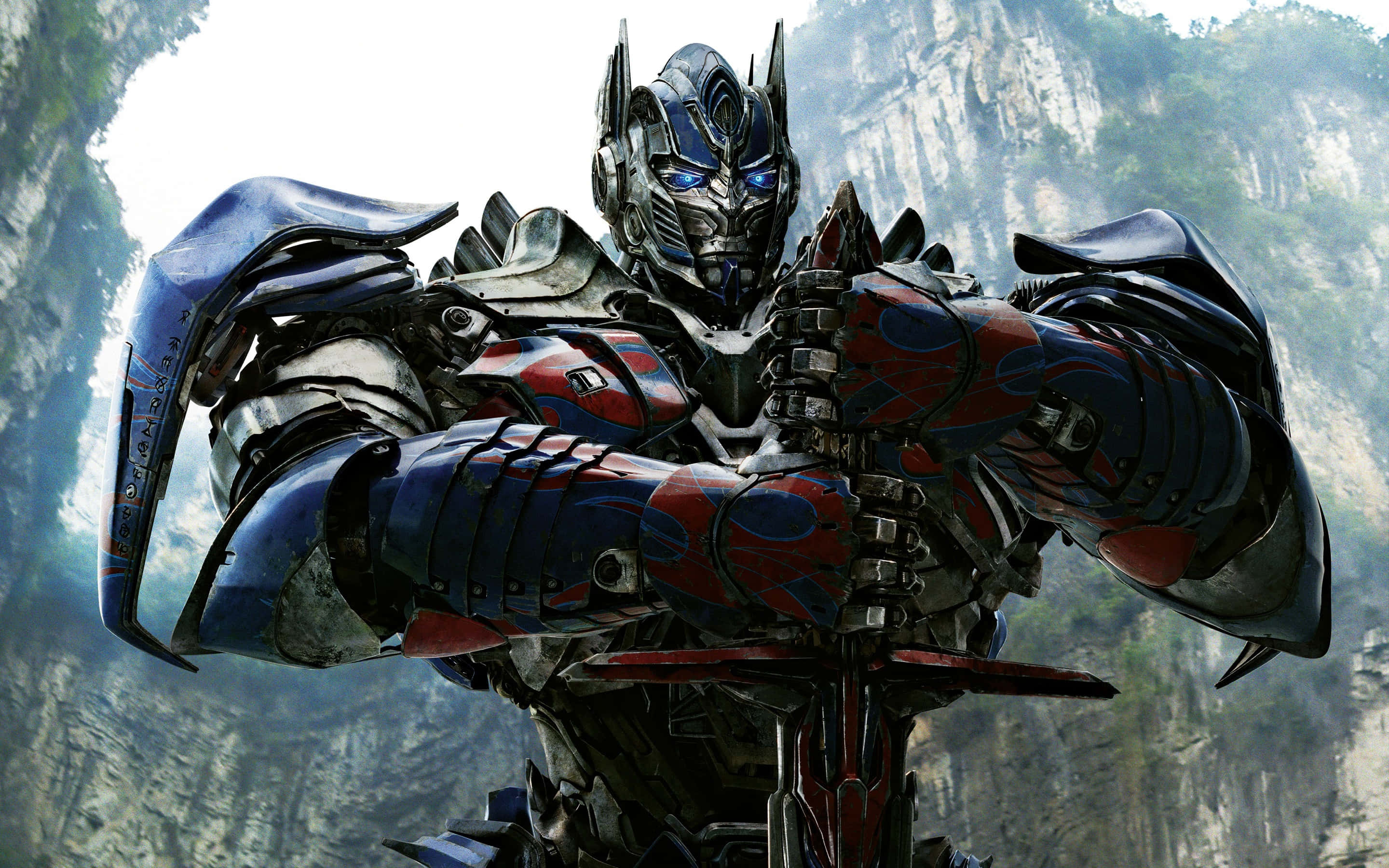 Optimus Prime en cañón montañoso con ojos brillantes y armadura roja y azul. — Transformers Fondos de pantalla
