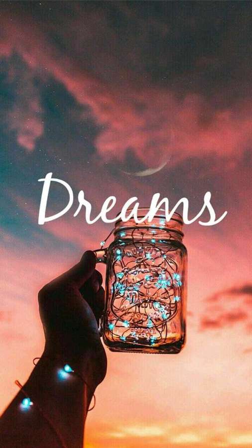 Hand hält Glas mit leuchtenden Lichtern vor Abendhimmel mit Mondsichel und Wort Dreams. — Traum Wallpaper