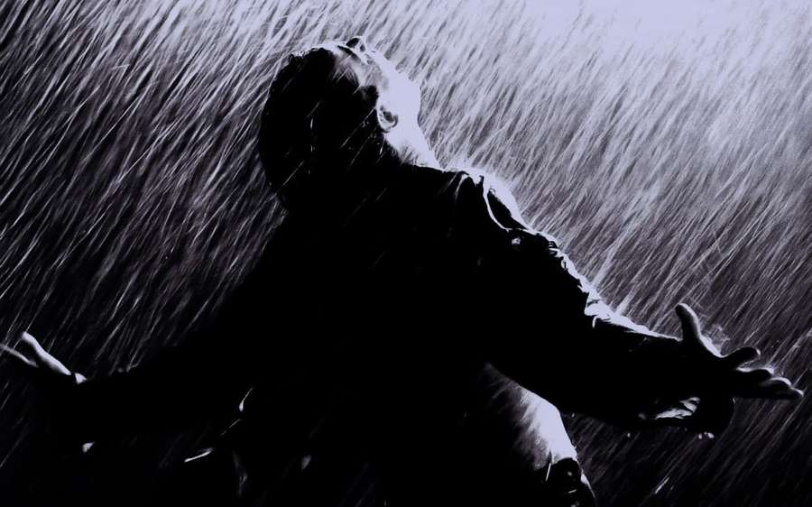 Person umarmt den Regen mit weit geöffneten Armen in einer dunklen stürmischen Szene. — Traurigkeit Wallpaper