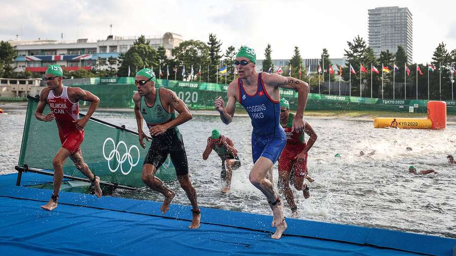 Triathleten sprinten beim Übergang vom Schwimmen zum Laufen bei den Olympischen Spielen 2020 in Tokio. — Triathlon Bilder