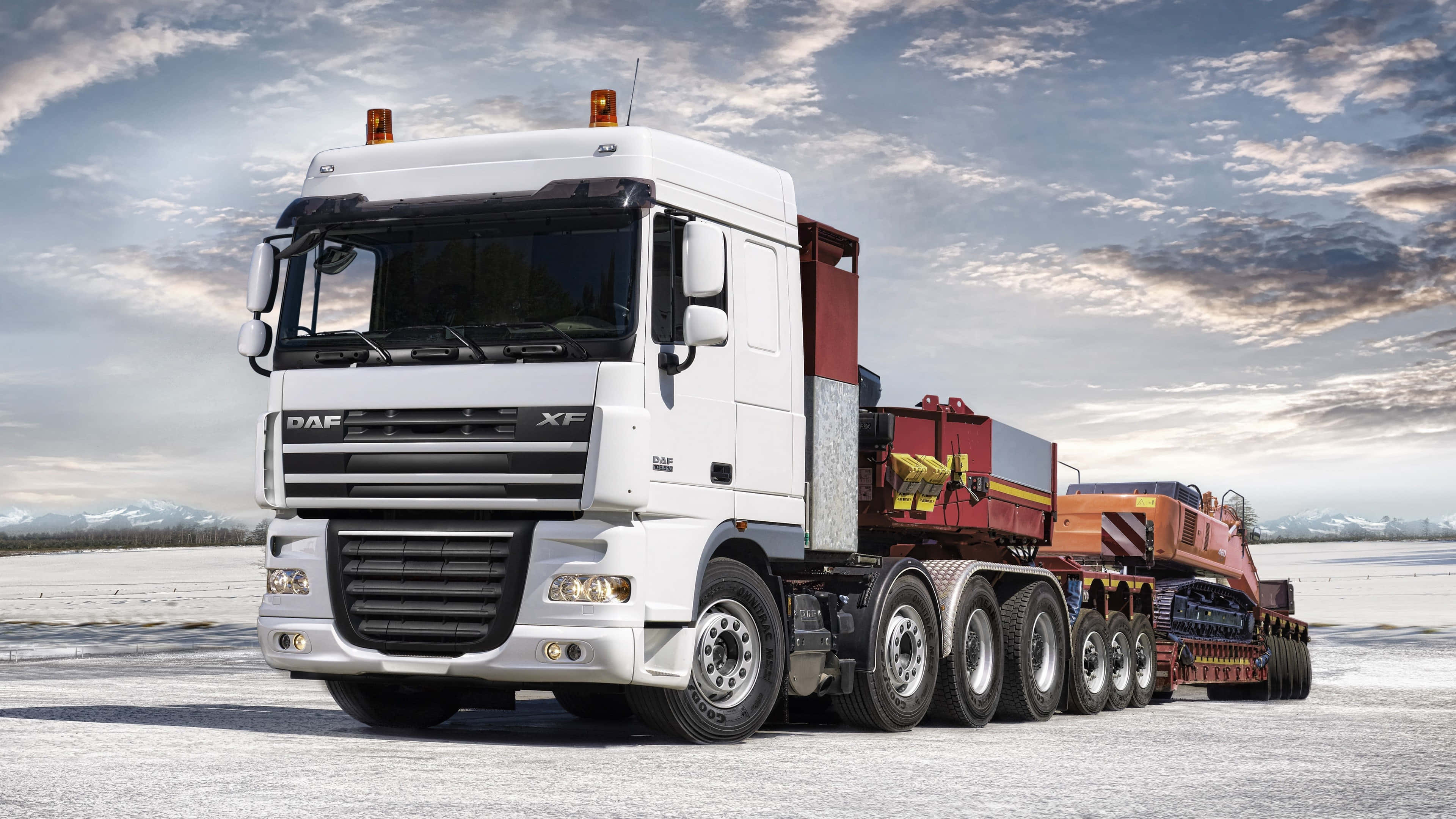 White DAF XF truck hauling equipment through snowy field at dawn. — Truck Background