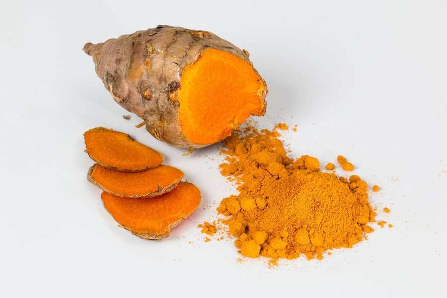 Fresh turmeric root and ground powder on white surface — Turmeric Wallpaper