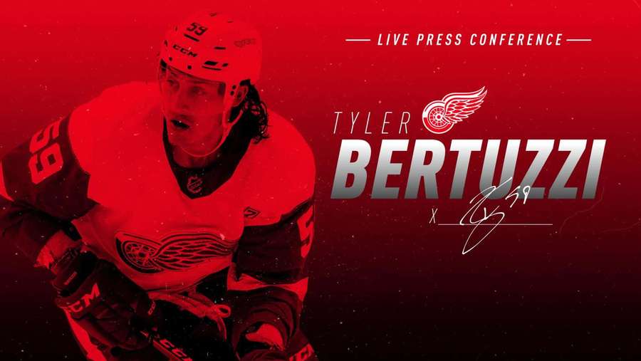 Hockey player Tyler Bertuzzi in Red Wings gear at a press conference. — Tyler Bertuzzi Wallpaper