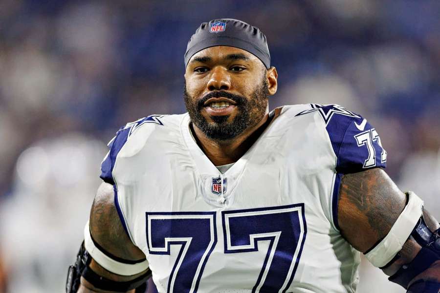Dallas Cowboys football player wearing number 77 jersey during a night game. — Tyron Smith Wallpaper