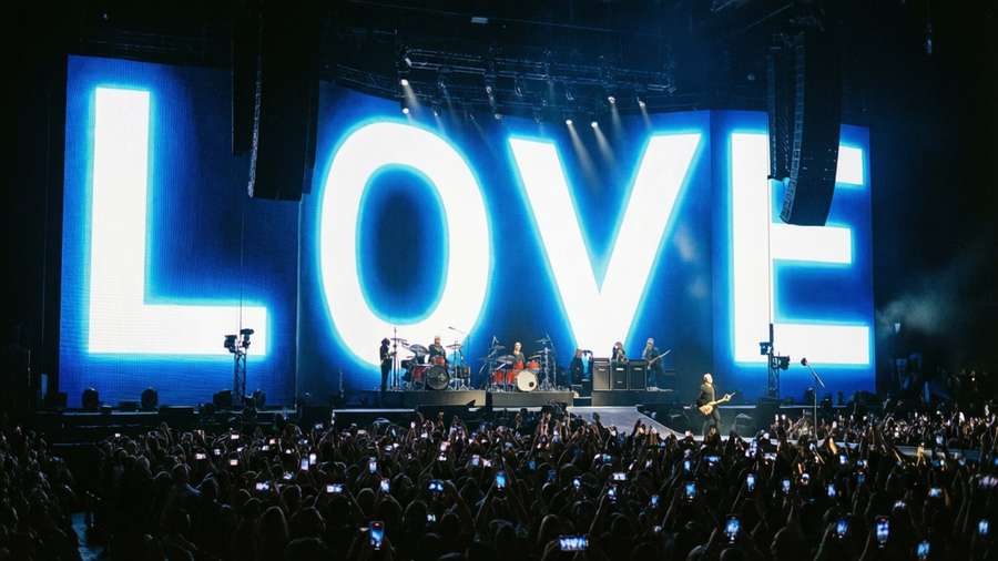 U2 with 'LOVE' on screen and phone lights, panoramic concert shot. — U2 Wallpaper