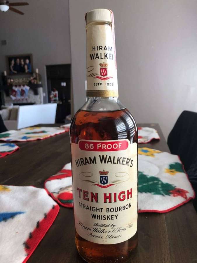 Uma garrafa de uísque bourbon Hiram Walker's Ten High sobre uma mesa de madeira com jogos americanos de Natal. — Uísque Papéis de Parede