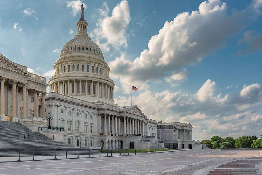 The U.S. Capitol Building with a blue sky and white clouds. — United States Background