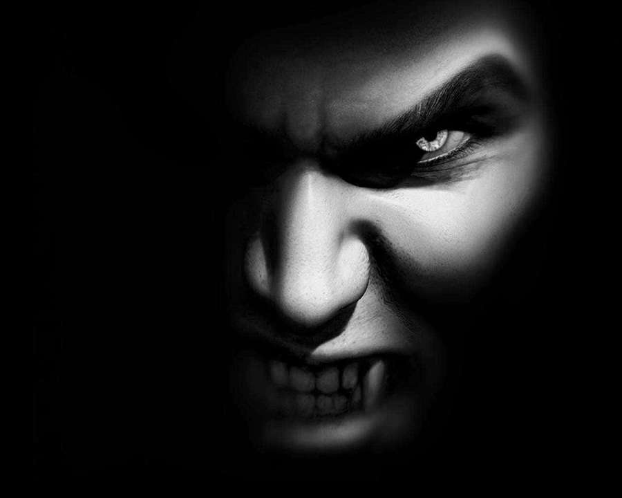 Close-up of a vampire's face with sharp fangs and glowing eyes in black and white. — Vampire Background
