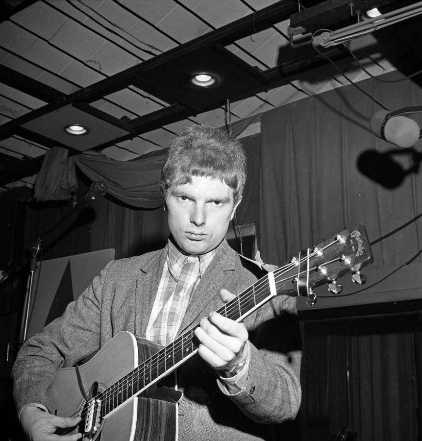 Man playing acoustic guitar on stage under spotlights — Van Morrison Background