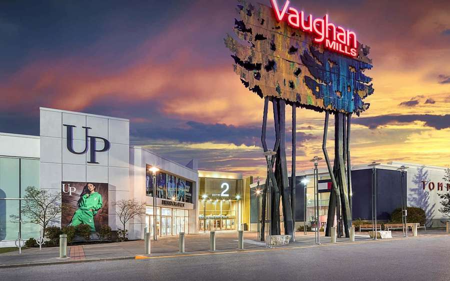 Vaughan Mills shopping mall entrance at sunset with a large tree sculpture and glowing signs. — Vaughan Canada Wallpaper