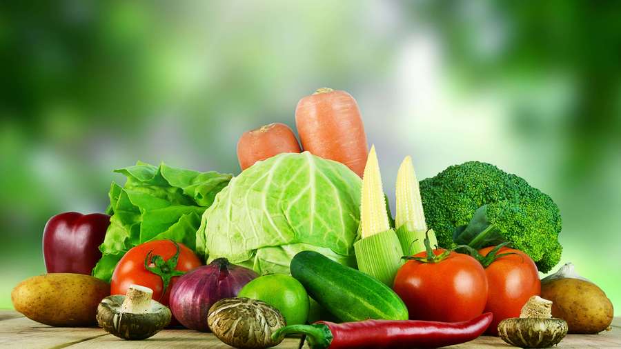 A colorful assortment of fresh vegetables on a wooden table. — Vegetables Picture