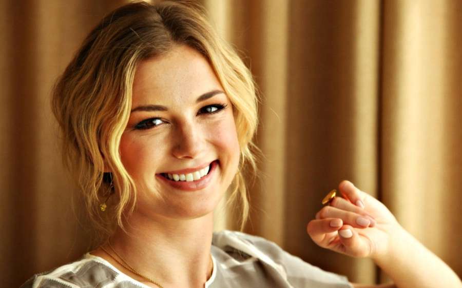 Una rubia sonriente sosteniendo un pequeño objeto de oro en el interior. — Venganza Fondos de pantalla